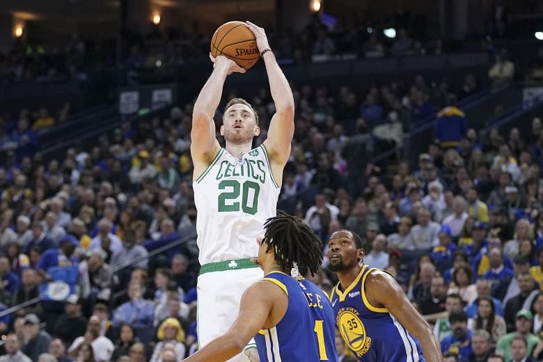 Boston Celtics' Gordon Hayward shooting over Golden State Warriors' Damion Lee and Kevin Durant during their game at the Oracle Arena on Tuesday night. The forward led all scorers with 30 points, as Boston overwhelmed the NBA defending champions 128-