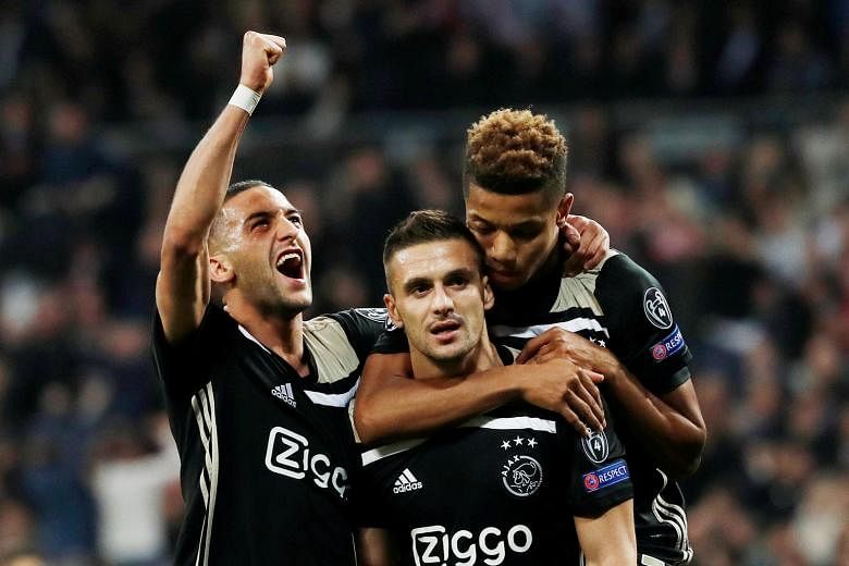 Real Madrid goalkeeper Thibaut Courtois grasping at thin air as a left-wing free kick from Lasse Schone soars past him into the top corner for Ajax's fourth goal at the Santiago Bernabeu. Dusan Tadic (centre) celebrates scoring their third goal with 