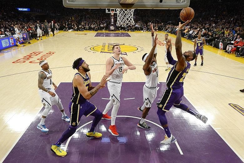 LeBron James of the Los Angeles Lakers scoring the basket that takes him past Michael Jordan on the all-time scoring list at the Staples Centre on Wednesday. The Lakers' fourth straight defeat, 115-99 against the Denver Nuggets, puts them 61/2 games 