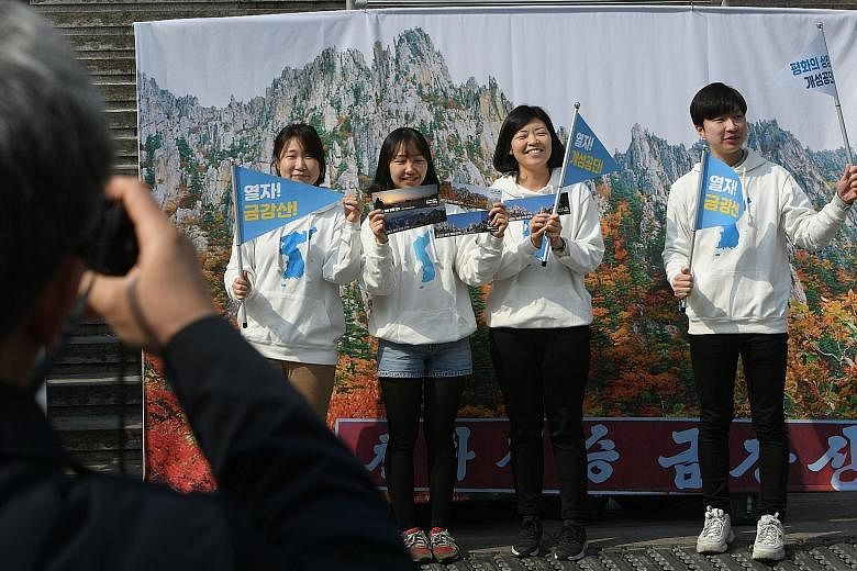 South Korean pro-unification activists in front of a banner showing North Korea's Mount Kumgang during a rally in Seoul yesterday. They were demanding the resumption of Mount Kumgang tours and the reopening of the Kaesong Industrial Complex in the No