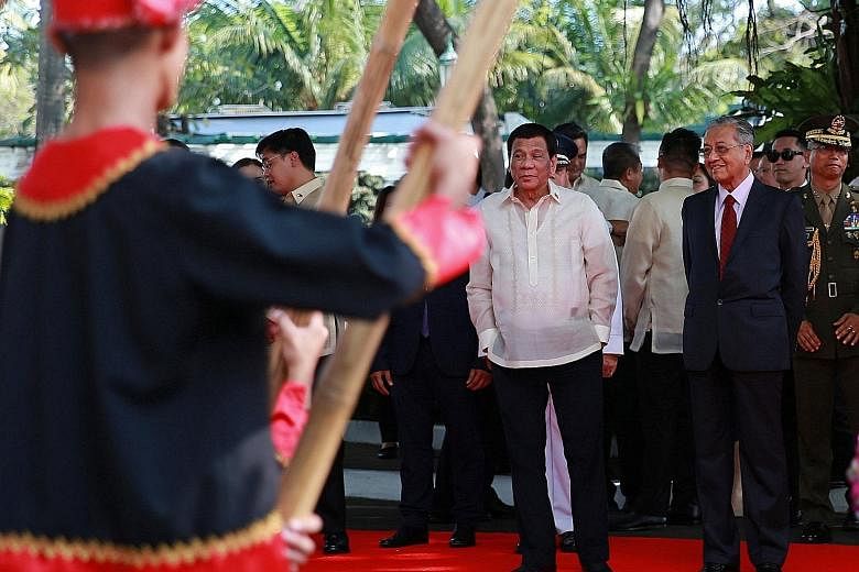Philippine President Rodrigo Duterte (centre) and Malaysian Prime Minister Mahathir Mohamad watching a welcome dance performance at Malacanang presidential palace in Manila yesterday.