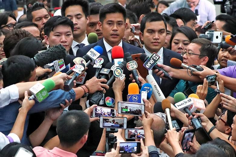 Thai Raksa Chart party leader Preechapol Pongpanit, accompanied by members of his party, speaking to the media after the verdict was handed down by the Constitutional Court yesterday.