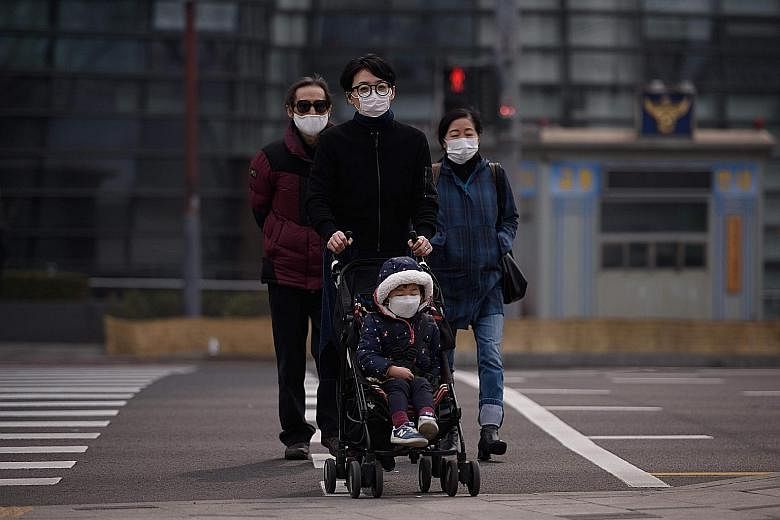 Masked policemen on guard outside the integrated government building in Seoul last Tuesday. A family taking precautions as they venture outside in Seoul. Anti-dust masks are flying off the shelves amid rising pollution. Apartment complexes in Seoul s
