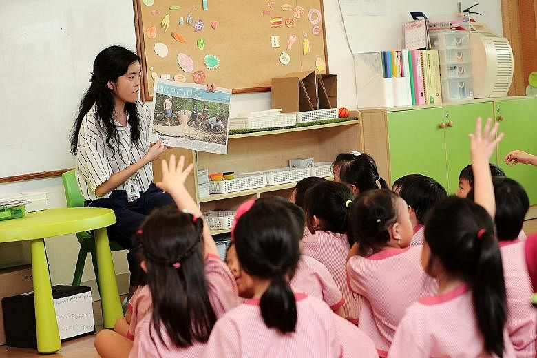 Teacher Chng Shu Min posing questions about the whale story published in The Straits Times as the children give their views on the subject.