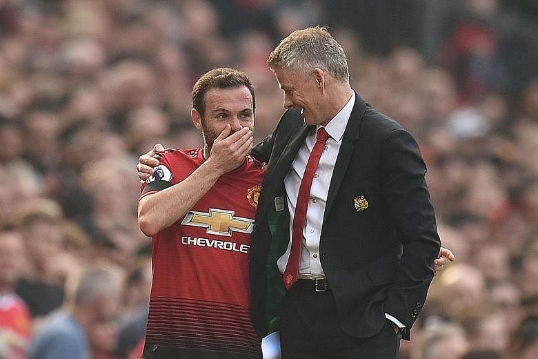 From top: Ole Gunnar Solskjaer showing his considerable motivational skills in consoling United's Spanish midfielder Juan Mata, who went off injured in the 0-0 home draw with Liverpool in the Premier League last month. The United caretaker boss has a