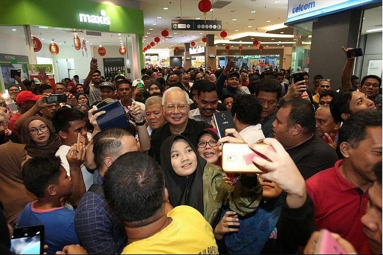 Former prime minister Najib Razak being mobbed at a Selangor hypermarket. Apart from attracting crowds, he has been an active government critic on social media.
