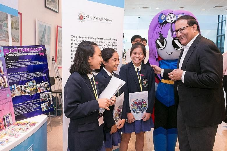 Mr S. Iswaran interacting yesterday with student exhibitors from CHIJ (Katong) Primary School at the Better Internet Conference 2019. The exhibition showcased 11 projects supported by the Media Literacy Council.