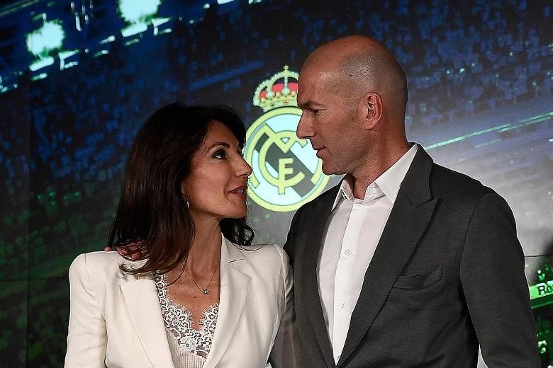 Real Madrid's newly appointed coach Zinedine Zidane posing with his wife Veronique after giving a press conference on Monday. The Frenchman has signed a three-year contract, just nine months after he resigned from the club, having led them to an hist
