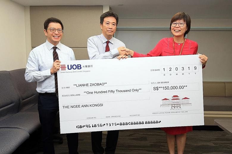 Ngee Ann Kongsi vice-president Jamie Teo (far left) and president Richard Lee handing over a cheque yesterday to Ms Lee Huay Leng, head of SPH's Chinese Media Group. The beneficiaries will receive free print subscriptions to Lianhe Zaobao for a year.