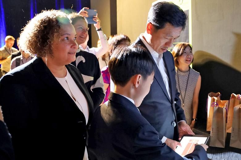 Education Minister Ong Ye Kung trying out a game with Pathlight School student Kaeden Chan at yesterday's launch of coding programme Swift Accelerator. With them was Ms Lisa Jackson from Apple.