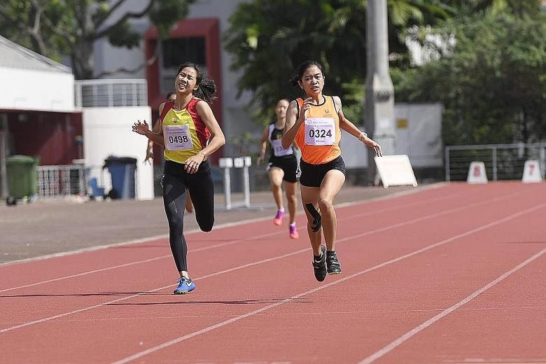 Diane Pragasam from the Singapore Sports School sprinting to the finish line to hold off Hwa Chong Institution's Amanda Woo to win the A Division 400m in a personal-best 61.00 seconds at Choa Chu Kang Stadium yesterday.