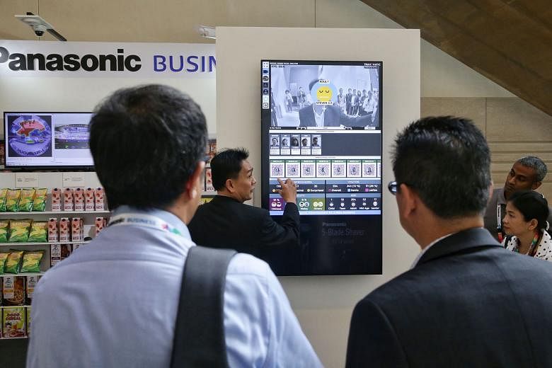 Right: Panasonic Security Solutions business division head Alvin Quek demonstrating the FacePRO facial recognition software. Below: A Panasonic staff member showing how the latest smart cameras and built-in analytics can be used by retailers.