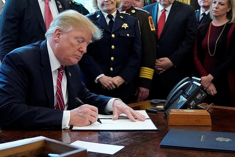 US President Donald Trump signing his veto of the congressional resolution to end his emergency declaration to get funds for a border wall during a ceremony at the Oval Office last Friday. He had already signalled his move, which was expected, on Twi