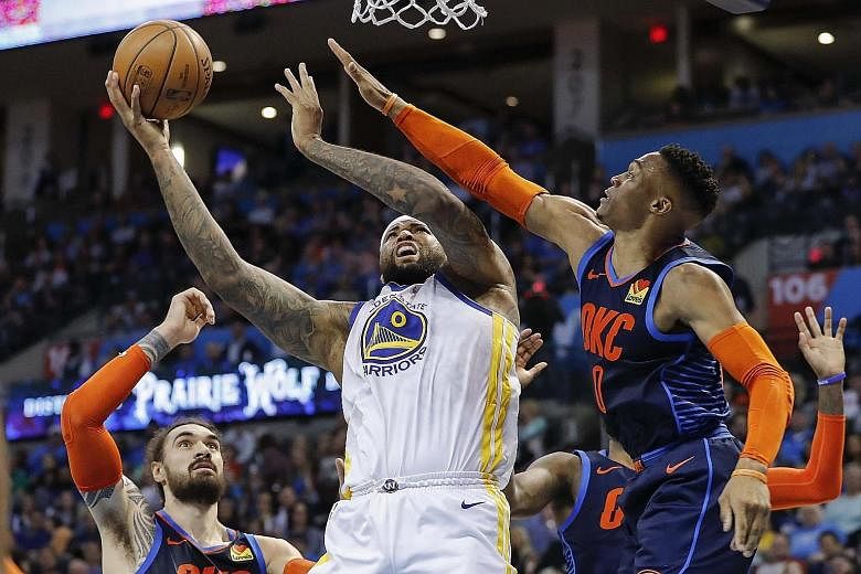 Golden State centre DeMarcus Cousins going up for a basket as Oklahoma City guard Russell Westbrook defended during the first half at the Chesapeake Energy Arena on Saturday. The Warriors won 110-88.