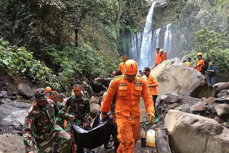 Rescuers carrying the body of Malaysian Lim Sai Wah, who died in a landslide triggered by an earthquake in Lombok on Sunday. Two other people died in the incident - another Malaysian and an Indonesian.