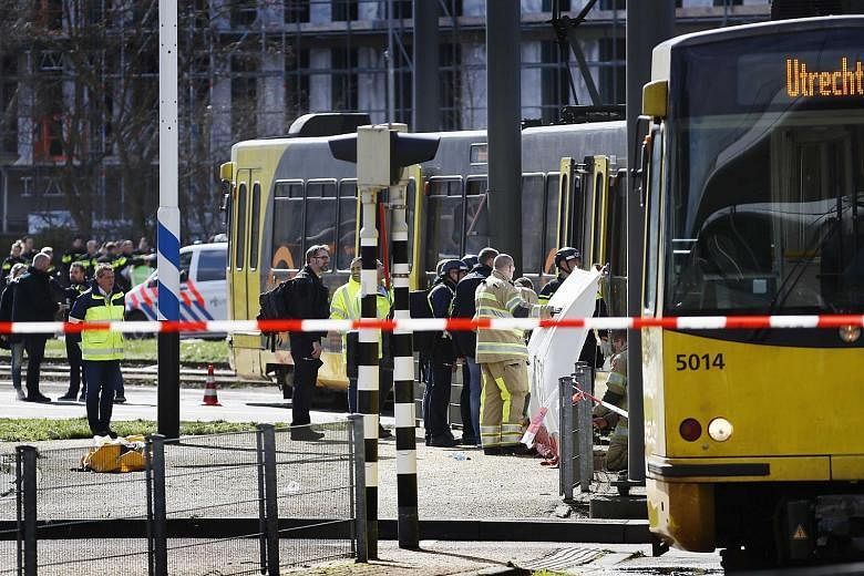 Emergency workers responding to a shooting on a tram in the Dutch city of Utrecht yesterday. The police are hunting for a 37-year-old man born in Turkey in connection with the incident, which has been described as a possible terror attack.