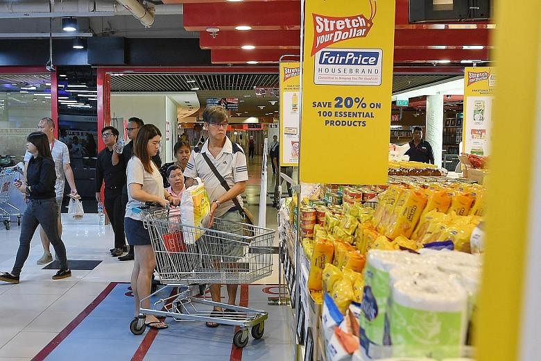Shoppers at the FairPrice Xtra outlet in Kallang Wave Mall yesterday. The 100 house brand products whose prices have been frozen include rice, cooking oil, poultry, toiletries and household cleaning items.