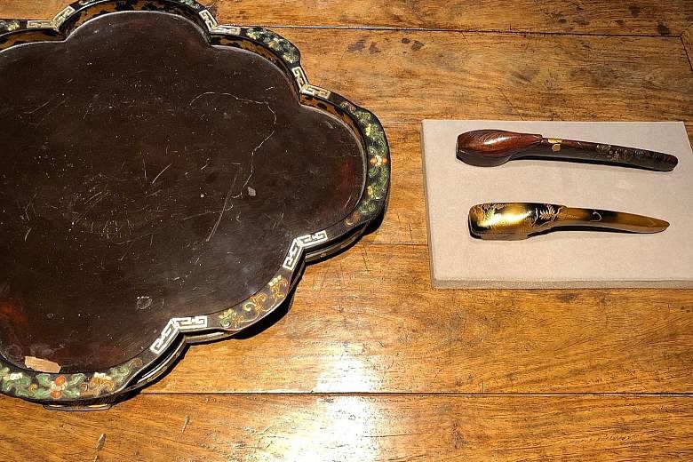 A Qing dynasty leaf-shaped tray (left) and two Meiji period yatate (right) for storing writing brushes and ink. A Meiji period yatate, or writing brush case (front), and a Qing dynasty carved lacquer stand (back). A porcelain kiseru tobacco pipe from