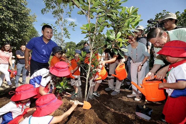 Second Minister for National Development Desmond Lee (in blue) joining around 50 pre-schoolers at a tree planting ceremony during the opening of the Nature Playgarden at HortPark yesterday. The new park, which has nine different play features, is par