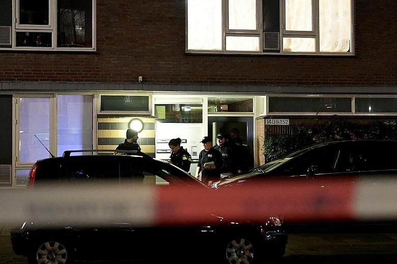 Police officers at the building in Utrecht on Monday where Gokmen Tanis, the main suspect in the shooting in the Dutch city on the same day, was arrested after a seven-hour manhunt. Flowers placed yesterday at the site of Monday's shooting in Utrecht