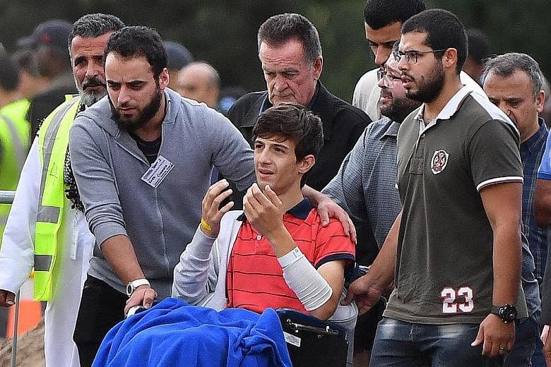 Zaid Mustafa, 13, the son and brother respectively of massacre victims Khaled and Hamza Mustafa, attending their funeral at the Memorial Park Cemetery in Christchurch yesterday. "I should be lying beside you," the injured boy was heard saying at thei