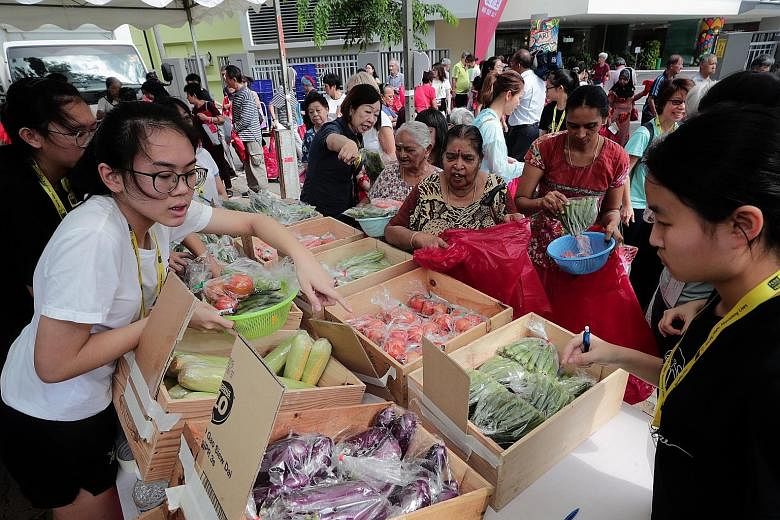 Madam Siti Aidah Abdullah (above) was one of the 500 beneficiaries at yesterday's charity pop-up market, which allowed needy beneficiaries to shop for $50 worth of fresh produce.