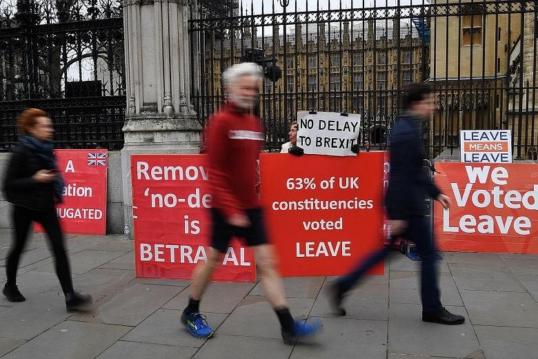 Pro-Brexit campaigners outside Parliament in London yesterday. British Prime Minister Theresa May has written to European Council president Donald Tusk to request a delay to Brexit until June 30.