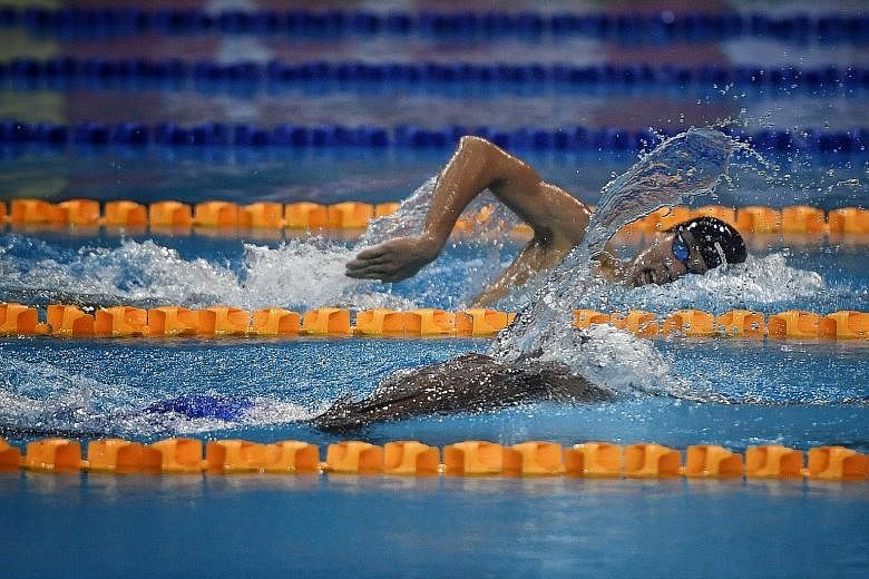 Singapore swimmer Glen Lim (in black cap) splashing his way to a national 400m freestyle record of 3min 52.64sec at the OCBC Aquatic Centre yesterday to add to his 800m free mark set on Tuesday.