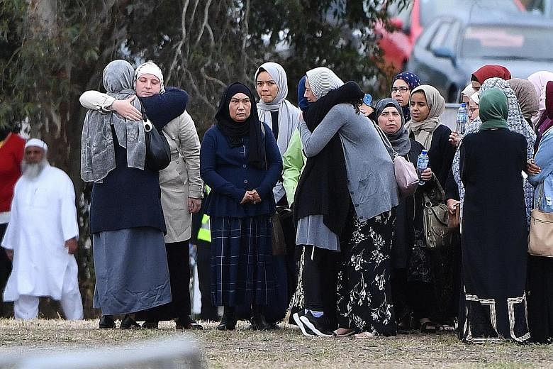 Mourners consoling one another at the funeral of 14-year-old Sayyad Ahmed Milne, one of the 50 people killed in last Friday's attacks on two mosques, at the Memorial Park Cemetery in Christchurch yesterday.