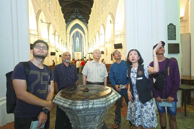 Ms Yap Soik Yee, a volunteer docent with St Andrew's Cathedral, pointing out the national monument's rich heritage to members of the Woodlands Malay Activity Executive Committee as well as mosque and temple leaders during their visit yesterday.