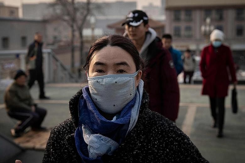 Above: A family looking for a rickshaw amid heavy smog in New Delhi, India's most polluted major city, last November. Right: A woman wearing a protective mask to fight the severe air pollution in Beijing in February. China and India have begun to pay