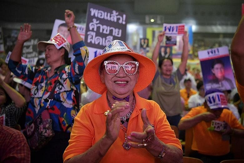Pheu Thai supporters attending the party's rally at an indoor stadium in the Thai-Japan Youth Centre in Bangkok yesterday. Although analysts expect Pheu Thai and the Democrat Party to win the most number of seats, the odds are stacked heavily in favo