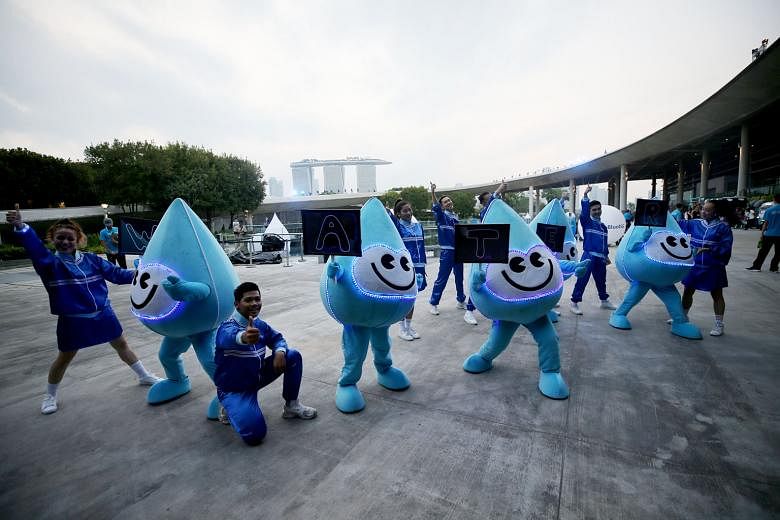 Water Wally parade participants getting ready for the GoBlue4SG night carnival at Marina Barrage yesterday to mark World Water Day. A record 30 landmarks and buildings, including Marina Bay Sands, turned blue yesterday to support water conservation.