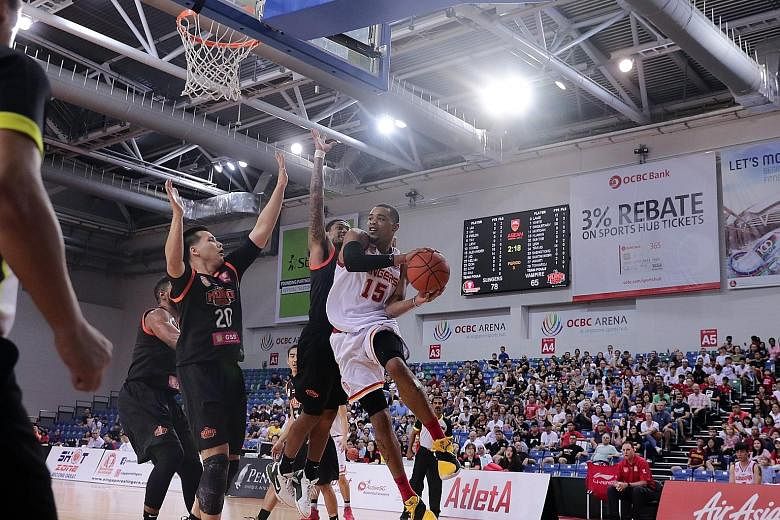 Mono Vampire players trying to prevent Singapore Slingers' Xavier Alexander from scoring at the OCBC Arena yesterday, but he scored 26 points to become the ABL's all-time leading scorer with 2,062 points.