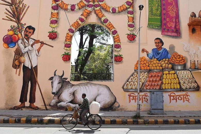 A cyclist riding past colourful murals in New Delhi's Lodhi art district, the first public art district in India. Located in the capital city's Lodhi colony, the art district is home to many murals by some 35 artists from India and around the world. 