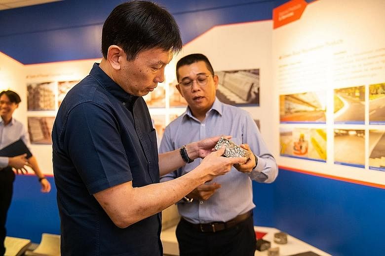 Samwoh chief executive officer Eric Soh (right) handing Senior Minister of State for Trade and Industry and Education Chee Hong Tat a sample of recycled material in the Samwoh Innovation Centre at Samwoh Eco-Green Building.