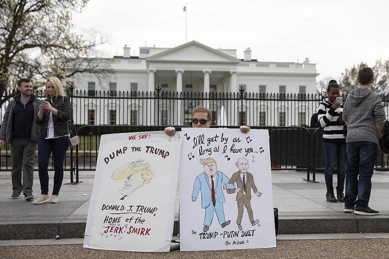 A protester outside the White House in Washington on Sunday. Investigations into President Donald Trump will continue, led by House committees, which are under the control of the Democrats.
