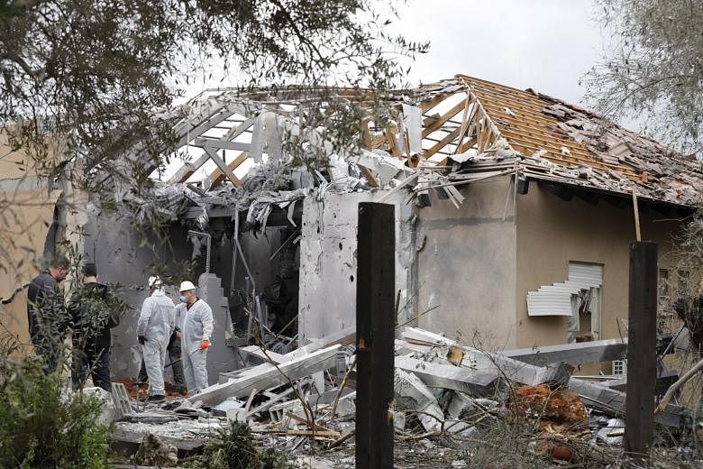 Israeli police examining a house in Moshav Mishmeret, north of Tel Aviv, yesterday that was hit by a rocket that the military said was launched by Hamas from about 120km away. There has been no claim of responsibility for the early morning strike.