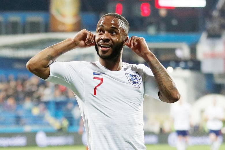 Montenegro fans appearing to goad England left-back Danny Rose during the Three Lions' 5-1 win in Podgorica on Monday. The victory gave Gareth Southgate's men two wins out of two Euro 2020 qualifiers. Below: England forward Raheem Sterling cupping hi
