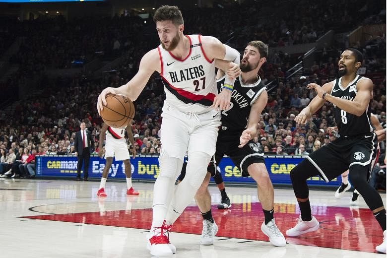 Portland Trail Blazers centre Jusuf Nurkic making a move to the basket against Brooklyn Nets forward Joe Harris and guard Spencer Dinwiddie (No. 8). The Trail Blazers won the game 148-144 in double overtime and clinched a play-off spot for the sixth conse