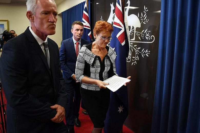 Australia's One Nation leader Pauline Hanson, flanked by party officials Steve Dickson (left) and James Ashby, after a press conference yesterday over the two men's involvement in a scandal over soliciting funds from a US lobby in return for weakenin