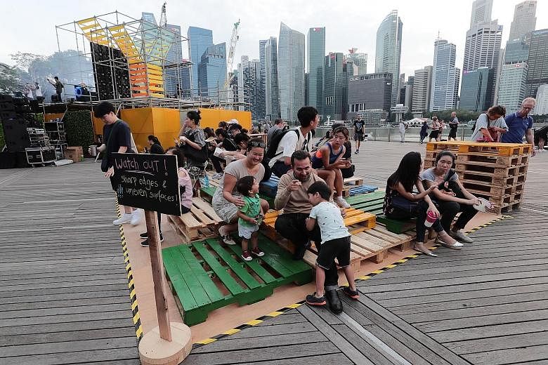 Mr Sameer Grover and his wife Lisa Teo, both 38, enjoying family time with their children Nathaniel, three, and Ethan, one, on recycled wooden pallets at the Earth Hour 2019 festival yesterday.