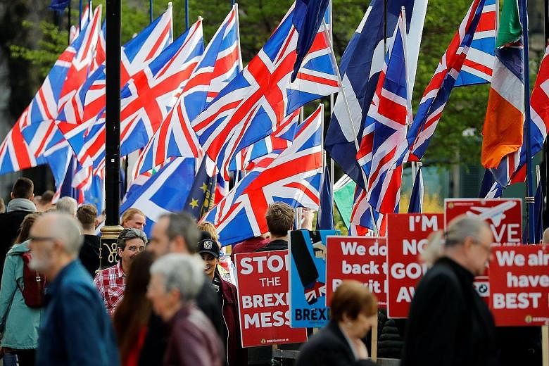 Pro-Brexit activists and anti-Brexit demonstrators outside the Houses of Parliament in Westminster in London on Thursday. It is unclear if British Prime Minister Theresa May has the political capital left to try her deal a fourth time.
