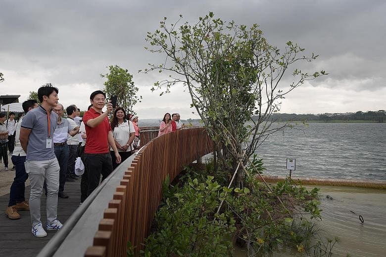 Minister for National Development Lawrence Wong (in red) at Rower's Bay, where he opened a new park yesterday.