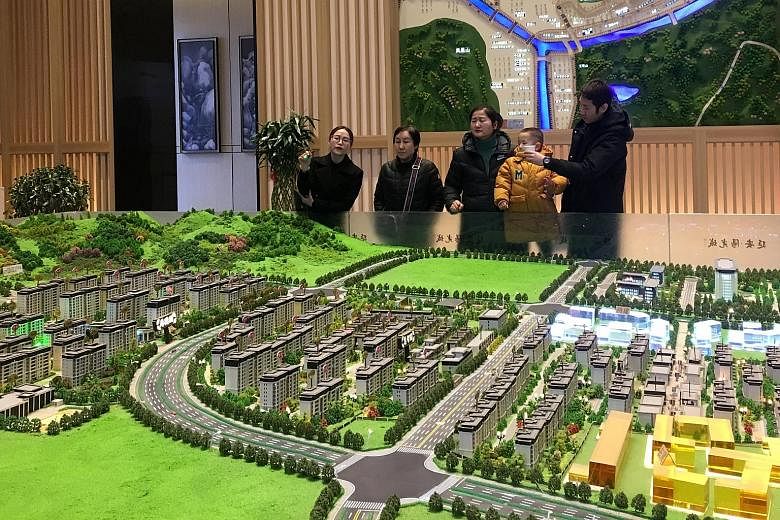 A sales agent in Shaanxi province, China, giving a sales pitch at a real estate showroom. For more than a decade, China has been considering a nationwide property tax but it has not happened due to resistance from property developers and owners, and 
