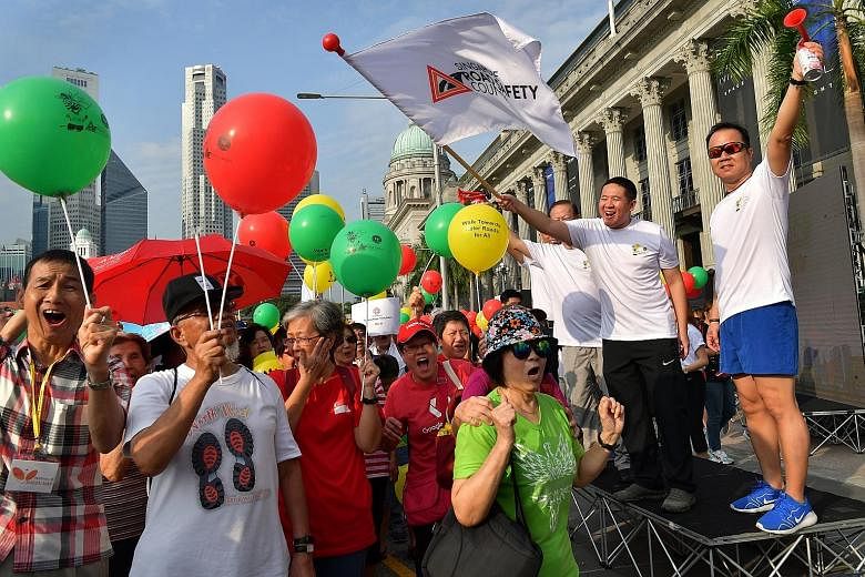 Senior Parliamentary Secretary for Home Affairs and for Health Amrin Amin (second from right) and Singapore Road Safety Council chairman Bernard Tay (on Mr Amrin's right) flagging off the 1.5km walkathon outside the National Gallery Singapore yesterd