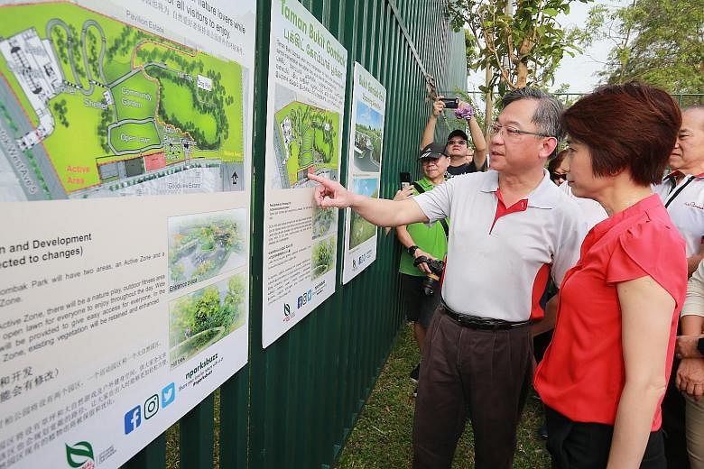 Health Minister Gan Kim Yong and Senior Parliamentary Secretary for Education and Manpower Low Yen Ling looking at a map of the upcoming Bukit Gombak Park, which will have a 400m walking trail and features such as a community garden and dog run.