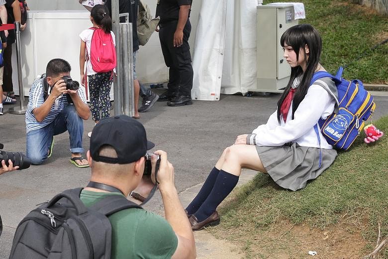 Cosplayers dressed up as a Japanese schoolgirl (above), as well as Ryuk (left) from anime Death Note, and characters (from far left) Monster Hunter, Kamen Rider Cross-Z, SIC Kamen Rider Gaim and Kamen Rider Cross-Z Magma striking a pose at the Sakura