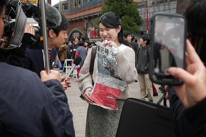 A TV crew interviewing a woman who managed to obtain a newspaper's extra edition reporting the announcement of the new era's name. The Oak Door's head chef Patrick Shimada, with the 3kg whopper to commemorate the coronation of Crown Prince Naruhito o