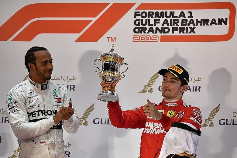 A heartbroken Charles Leclerc with his third-place trophy as winner Lewis Hamilton leads the cheers at the Sakhir circuit.